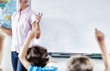 Teacher teaching kids in classroom at school